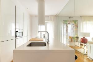 a white kitchen with a sink and a microwave at Apartamento de lujo en Calle Gravina in Seville