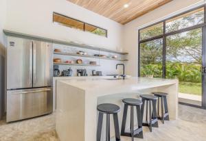 a kitchen with a large island with bar stools at Casa Arcilla NEW LISTING in Nosara