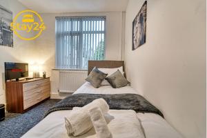 a bedroom with a bed and a dresser and a window at Mill House Manor in Crewe