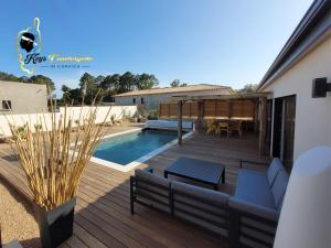 une terrasse avec un canapé et une table à côté d'une piscine dans l'établissement Villa du Soleil 8 pers piscine chauffée, à Lecci