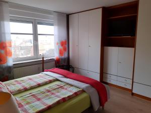 1 dormitorio con 1 cama, TV y ventana en Ferienwohnung AMBIENTE, en Bremerhaven