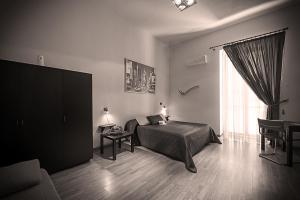 a bedroom with a bed and a large window at Albergo Tripoli B&B Affittacamere in Corato