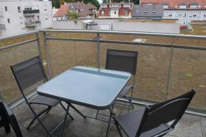 a white table and chairs on a balcony at Appartement confortable avec parking privé in Schiltigheim