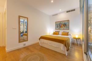 a bedroom with a large bed and a mirror at Apartamento de lujo en Calle Gravina in Seville