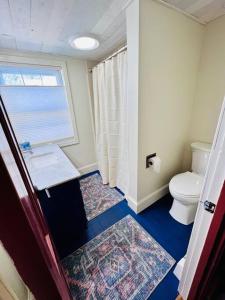baño con aseo y ventana en Circa 1725 home w/Roof Deck and Water Views en Newburyport