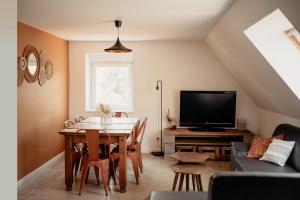 ein Wohnzimmer mit einem Tisch und einem TV in der Unterkunft Duplex cosy Le Boho in Guebwiller