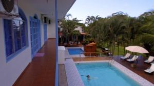 a person in a swimming pool next to a house at Boutique Hotel IBIZA in Jacó