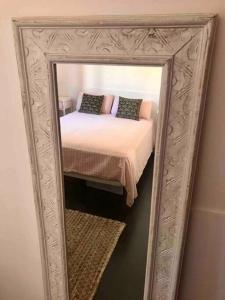 a mirror reflecting a bedroom with a bed in it at Vida Soladana - Cala en Forcat - piscina, playa, A/C, Smart TV... in Cala en Forcat