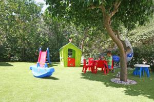 uma criança a brincar num parque infantil em Corina Suites & Apartments em Limassol