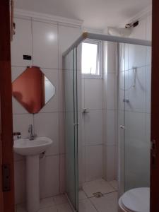 uma casa de banho com um chuveiro, um lavatório e um WC. em Apto150 m praia piscina Wi-Fi 6pessoas na Praia Grande
