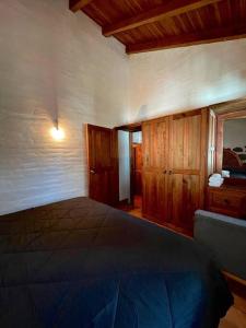 1 dormitorio con 1 cama grande y armarios de madera en Cabaña la Toscana en Mazamitla