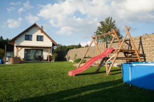 un parco giochi con scivolo in un cortile con una casa di Chata Miki a Boskovice