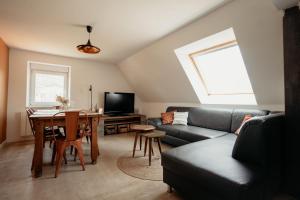 ein Wohnzimmer mit einem Sofa und einem Tisch in der Unterkunft Duplex cosy Le Boho in Guebwiller