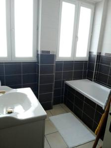 La salle de bains est pourvue d'une baignoire, d'un lavabo et de 2 fenêtres. dans l'établissement Appartement en RDC, à Argelès-sur-Mer