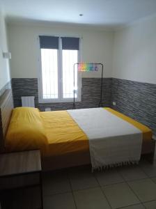 - une chambre avec un grand lit et une couverture jaune dans l'établissement Appartement en RDC, à Argelès-sur-Mer