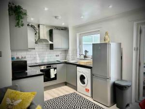a kitchen with a refrigerator and a washing machine in it at 2 Bedroom House -Sleeps 7- Big Savings On Long Stays! in Canterbury