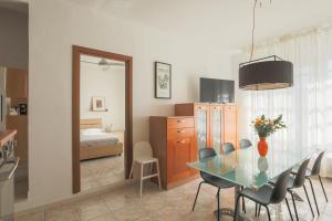 a dining room with a table and chairs and a bedroom at Casa Saffi in Livorno
