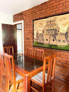 une table à manger avec des chaises et un tableau mural dans l'établissement Hotel Bougainville, à Penedo