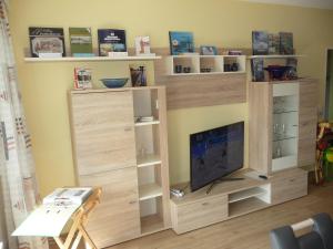 a large wooden entertainment center with a television in a room at Ferienwohnung AMBIENTE in Bremerhaven