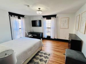 a bedroom with a bed and a desk and windows at Romantic West End Apartment with Parking in Portland