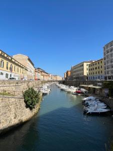 a river with boats in a city with buildings at Casa Saffi in Livorno