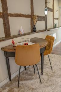 uma mesa de madeira e duas cadeiras num quarto em Chambre indépendante n3 - Bretzel et Bergamote em Richtolsheim