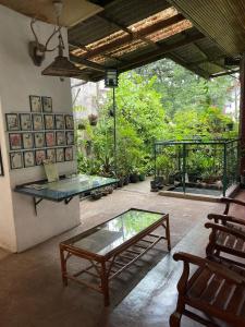 a room with a glass table and a bench at Kandy Inn Madugalle’s family guest house in Kandy