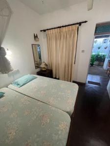 a bedroom with a bed and a window at Kandy Inn Madugalle’s family guest house in Kandy