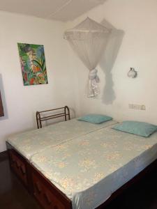 a bedroom with a bed with blue pillows at Kandy Inn Madugalle’s family guest house in Kandy