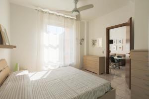 a bedroom with a bed and a dresser and a window at Casa Saffi in Livorno