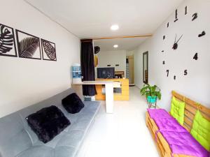 a living room with a couch and a clock on the wall at OSIMiRI PLAZA Apartamento Naturaleza y aventura in San Rafael
