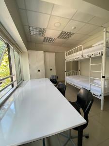 Cette chambre comprend 2 lits superposés, une table et des chaises. dans l'établissement Kadıköy Lina Apart Female Only, à Istanbul