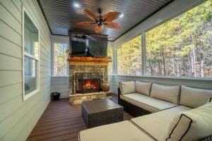 a screened in porch with a fireplace and a tv at Par-Tee Haus I- Game Room & Hot Tub-Walk to Helen in Helen
