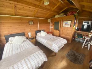 a bedroom with two beds in a wooden cabin at Carrowkeel Cabin in Sligo
