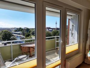 a balcony with two windows and a table and chairs at Ferienwohnung AMBIENTE in Bremerhaven
