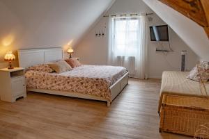 een slaapkamer met 2 bedden en een televisie op zolder bij Gîte indépendant - Bretzel et Bergamote in Richtolsheim