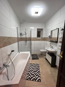 a bathroom with a tub and a toilet and a sink at Gera Apartment in Gera