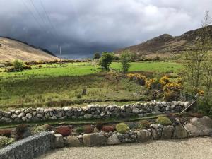 a stone wall in a field with a green field at Reid's Hall in Hilltown