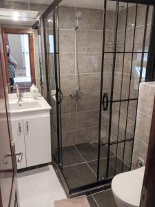 a bathroom with a shower and a sink at Beautiful stone guesthouse in cool Konak district in Konak