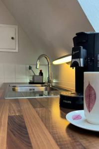 une cafetière et une tasse sur un comptoir dans l'établissement Am Eichhof, à Coblence