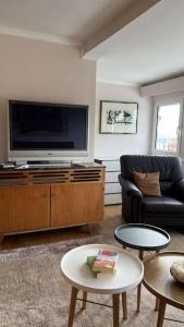 uma sala de estar com uma televisão, um sofá e mesas em Am Eichhof em Koblenz