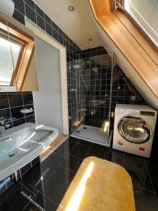een badkamer met een wastafel en een wasmachine bij Am Eichhof in Koblenz