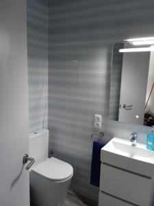 een badkamer met een wit toilet en een wastafel bij Vora Port in L'Ampolla