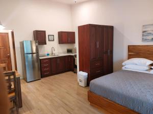 a bedroom with a bed and a kitchen with a refrigerator at Palm Beach Inn in Playa Grande