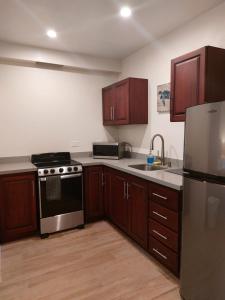 a kitchen with wooden cabinets and a stainless steel appliance at Palm Beach Inn in Playa Grande