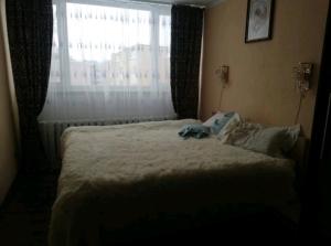 een slaapkamer met een groot bed en een raam bij Baby friendly 1-bedroom rental w/ free parking in Sigulda