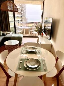 einen Tisch mit Tellern und Weingläsern im Wohnzimmer in der Unterkunft Studio Sea View - Royal Ascot in Ostende