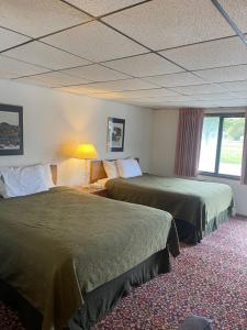 Habitación de hotel con 2 camas y ventana en Knights Inn Mackinaw City, en Mackinaw City
