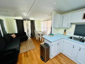 eine Küche und ein Wohnzimmer mit einem Sofa und einem Tisch in der Unterkunft Sunshine Tiny Home Pinecraft in Sarasota
