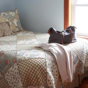 un bolso sentado en la parte superior de una cama en Fells Meadows Farmhouse on Country Property, en Castleton